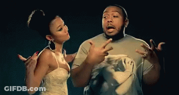A Man And A Woman Are Standing Next To Each Other And The Woman Is Pointing At The Man GIF