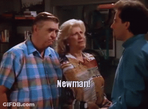 A Man And A Woman Are Standing Next To Each Other And The Woman Is Saying Newman GIF