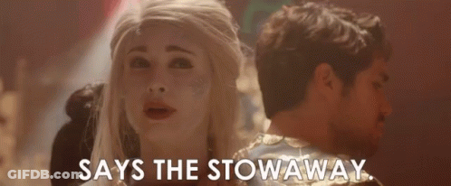 A Man And A Woman Are Standing Next To Each Other And The Woman Is Saying `` Says The Stowaway '' . GIF