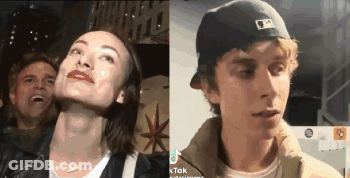 A Man And A Woman Are Standing Next To Each Other And The Woman Is Smiling And The Man Is Laughing . GIF