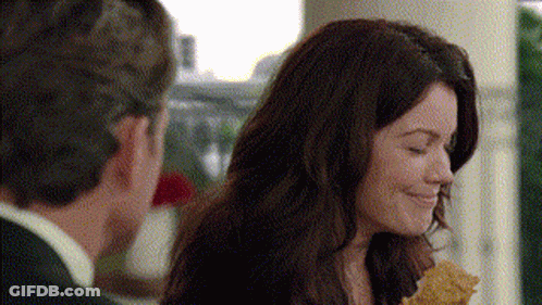 A Man And A Woman Are Standing Next To Each Other And The Woman Is Smiling While The Man Looks On GIF