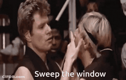 A Man And A Woman Are Standing Next To Each Other And The Woman Is Touching The Man 'S Nose . GIF