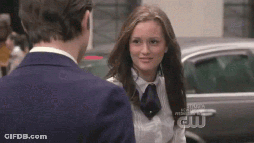 A Man And A Woman Are Standing Next To Each Other And The Woman Is Wearing A White Shirt And Tie . GIF