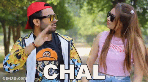 A Man And A Woman Are Standing Next To Each Other And The Woman Is Wearing Sunglasses And A Pink Shirt That Says Paradis GIF