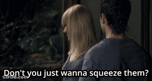 A Man And A Woman Are Standing Next To Each Other And The Woman Says " Don T You Just Wanna Squeeze Them " GIF