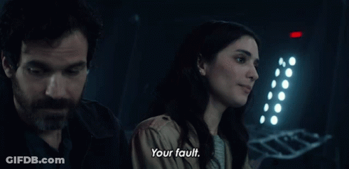 A Man And A Woman Are Standing Next To Each Other And The Woman Says Your Fault GIF