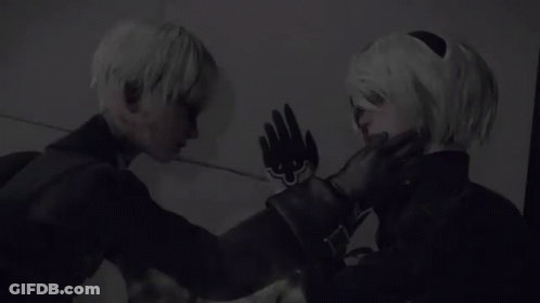 A Man And A Woman Are Standing Next To Each Other And Touching Their Faces . GIF