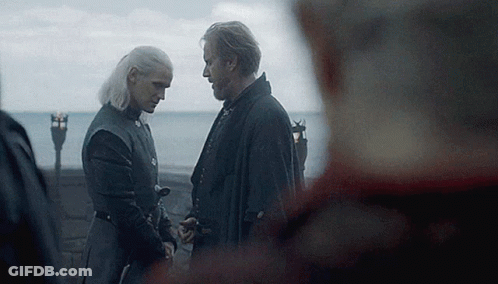 A Man And A Woman Are Standing Next To Each Other Holding Hands . GIF