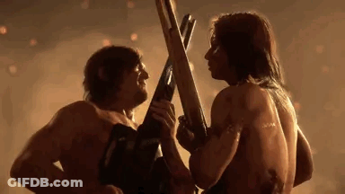 A Man And A Woman Are Standing Next To Each Other Holding Swords . GIF