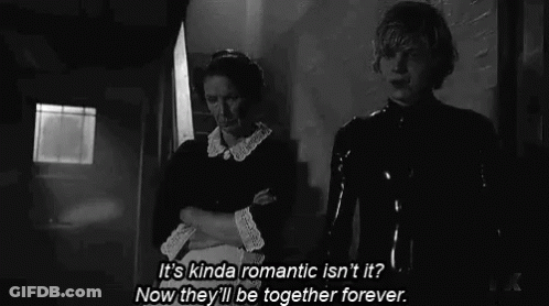 A Man And A Woman Are Standing Next To Each Other In A Black And White Photo . GIF