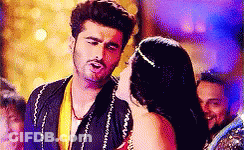 A Man And A Woman Are Standing Next To Each Other In A Crowded Room . GIF