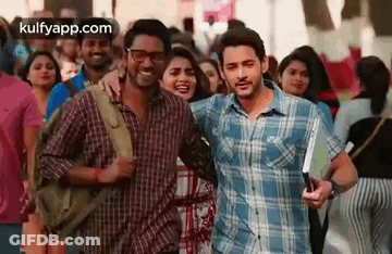 A Man And A Woman Are Standing Next To Each Other In A Crowded Street . GIF