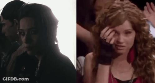A Man And A Woman Are Standing Next To Each Other In A Dark Room And A Woman Is Crying . GIF