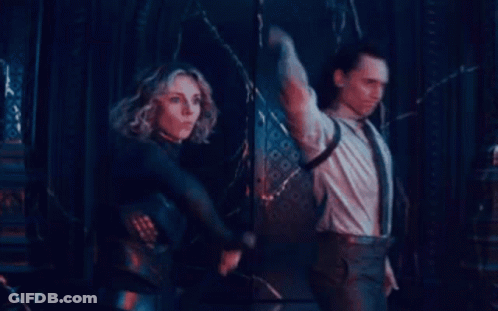 A Man And A Woman Are Standing Next To Each Other In A Dark Room Holding Swords . GIF