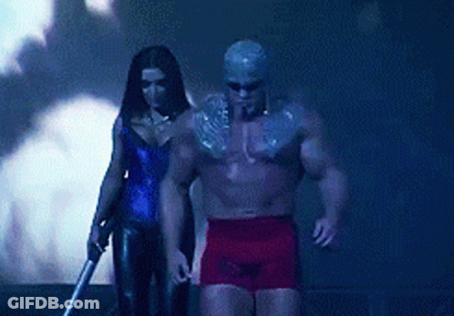 A Man And A Woman Are Standing Next To Each Other In A Dark Room GIF