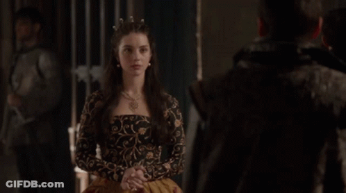 A Man And A Woman Are Standing Next To Each Other In A Dark Room . GIF