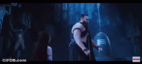 A Man And A Woman Are Standing Next To Each Other In A Dark Room With A Blue Light Coming Out Of Their Head . GIF