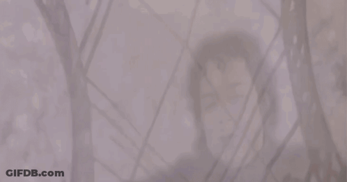 A Man And A Woman Are Standing Next To Each Other In A Foggy Room GIF