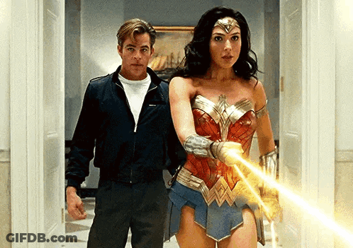 A Man And A Woman Are Standing Next To Each Other In A Hallway Holding A Light . GIF