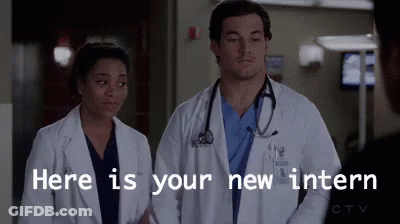 A Man And A Woman Are Standing Next To Each Other In A Hospital Room . GIF