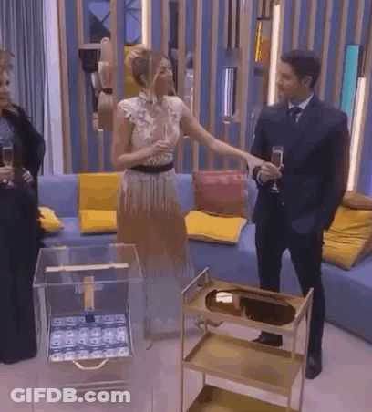 A Man And A Woman Are Standing Next To Each Other In A Living Room . GIF