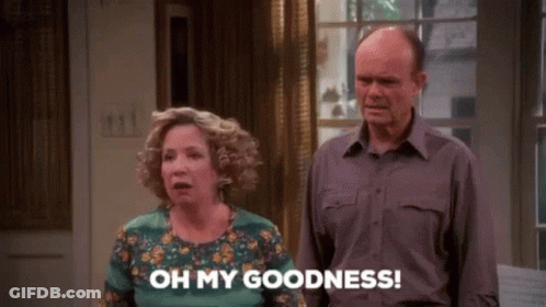 A Man And A Woman Are Standing Next To Each Other In A Living Room . GIF