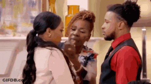 A Man And A Woman Are Standing Next To Each Other In A Living Room . GIF