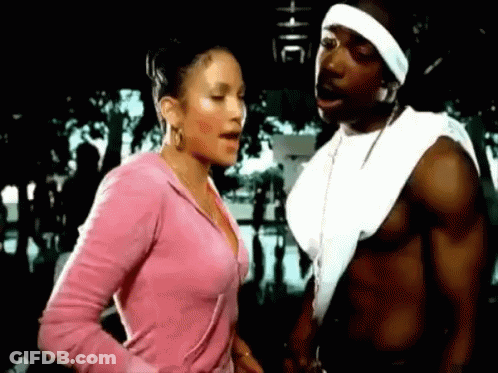 A Man And A Woman Are Standing Next To Each Other In A Park . GIF