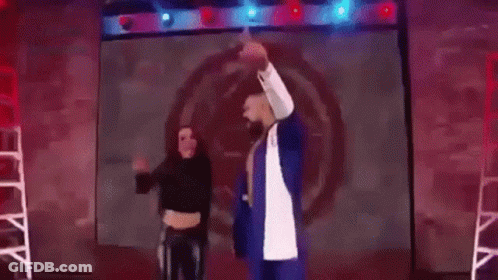 A Man And A Woman Are Standing Next To Each Other In A Ring . GIF