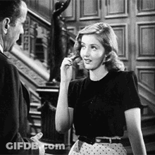 A Man And A Woman Are Standing Next To Each Other In A Room . GIF