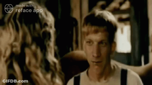 A Man And A Woman Are Standing Next To Each Other In A Room And Looking At Each Other . GIF