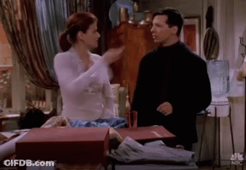 A Man And A Woman Are Standing Next To Each Other In A Room And Talking . GIF