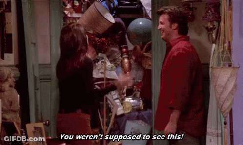 A Man And A Woman Are Standing Next To Each Other In A Room Filled With Lots Of Objects . GIF