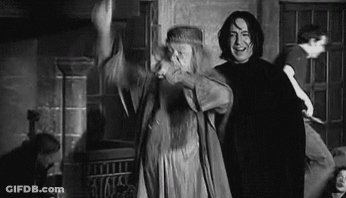 A Man And A Woman Are Standing Next To Each Other In A Room In A Black And White Photo . GIF