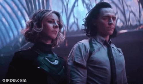 A Man And A Woman Are Standing Next To Each Other In A Room In A Movie . GIF