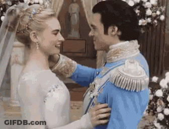 A Man And A Woman Are Standing Next To Each Other In A Room . GIF