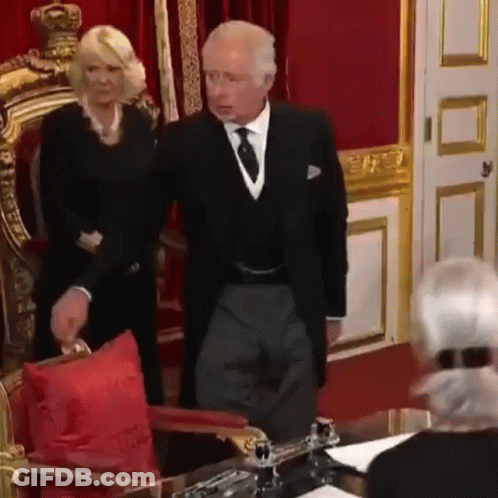 A Man And A Woman Are Standing Next To Each Other In A Room . GIF