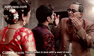 A Man And A Woman Are Standing Next To Each Other In A Room . GIF