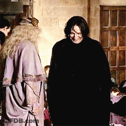 A Man And A Woman Are Standing Next To Each Other In A Room GIF