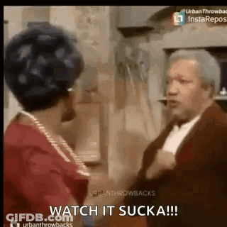 A Man And A Woman Are Standing Next To Each Other In A Room . GIF