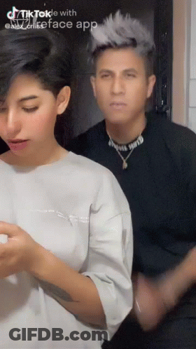 A Man And A Woman Are Standing Next To Each Other In A Tiktok Video . GIF