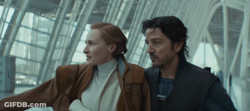 Man And Woman Standing Next To Each Other At Airport GIF