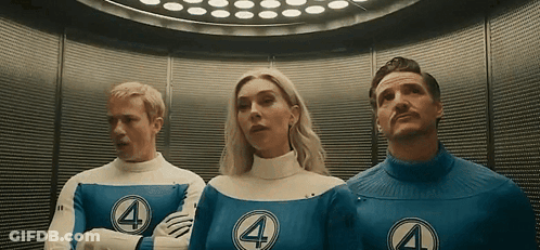 A Man And A Woman Are Standing Next To Each Other In An Elevator Wearing Fantastic Four Costumes . GIF