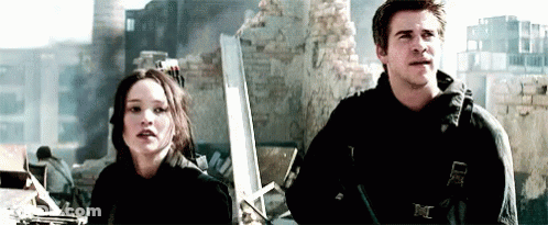 A Man And A Woman Are Standing Next To Each Other In Front Of A Building . GIF