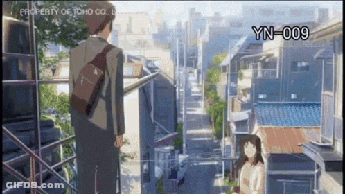 A Man And A Woman Are Standing Next To Each Other In Front Of A City Street . GIF