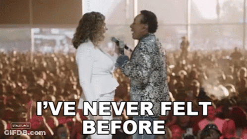 A Man And A Woman Are Standing Next To Each Other In Front Of A Crowd . GIF