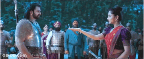A Man And A Woman Are Standing Next To Each Other In Front Of A Group Of Men . GIF