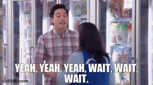 A Man And A Woman Are Standing Next To Each Other In Front Of A Refrigerator In A Store . GIF