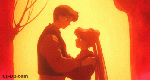 A Man And A Woman Are Standing Next To Each Other In Front Of A Tree GIF