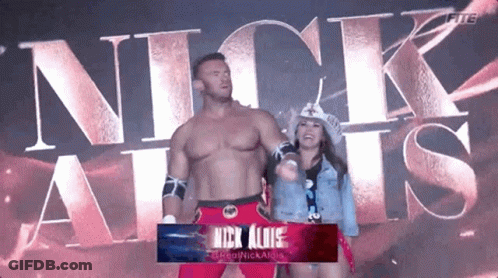 A Man And A Woman Are Standing Next To Each Other In Front Of The Word Nick Allis GIF